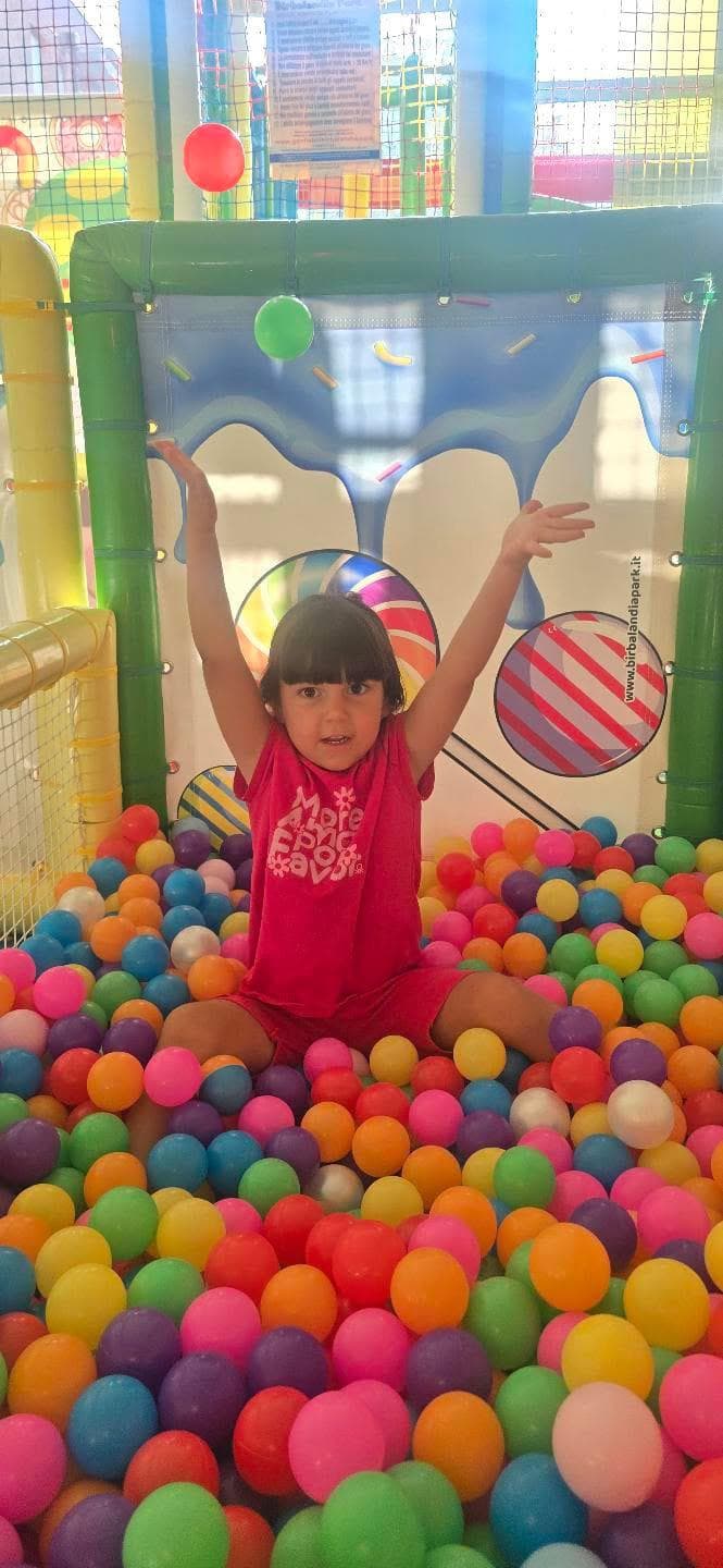 Bambina che gioca nella piscina di palline del PlayPark